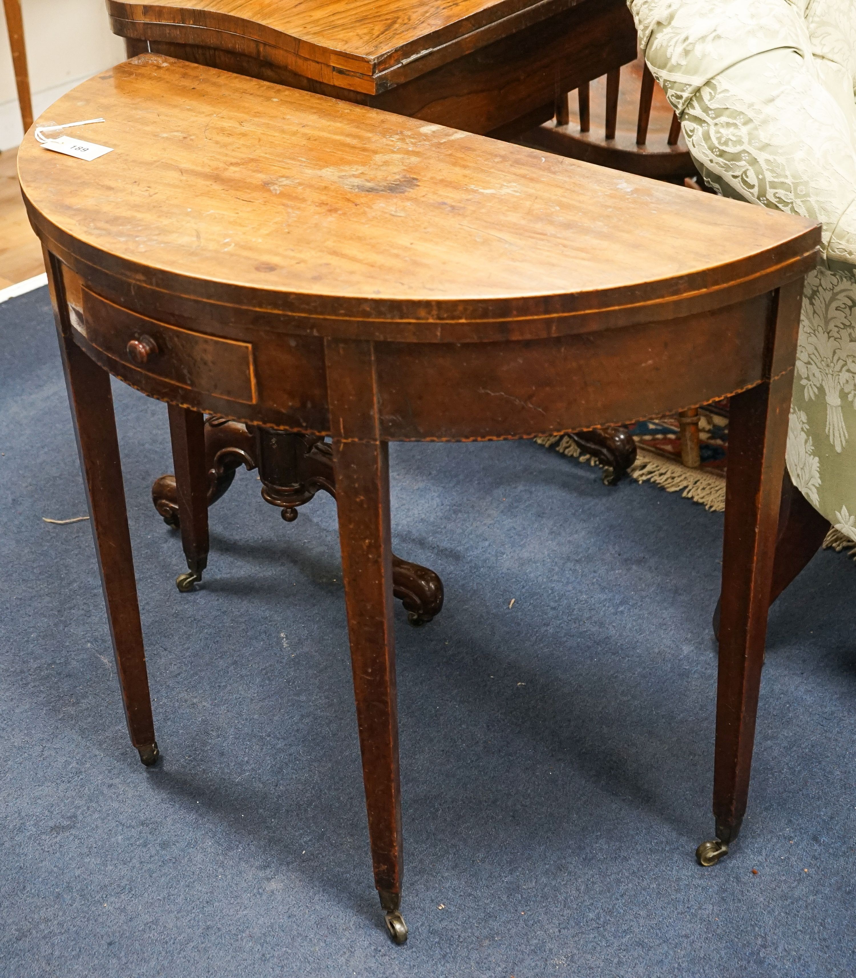 A Georgian mahogany demi-lune card table, with folding top on square tapered legs, width 86cm, depth 41cm, height 71cm